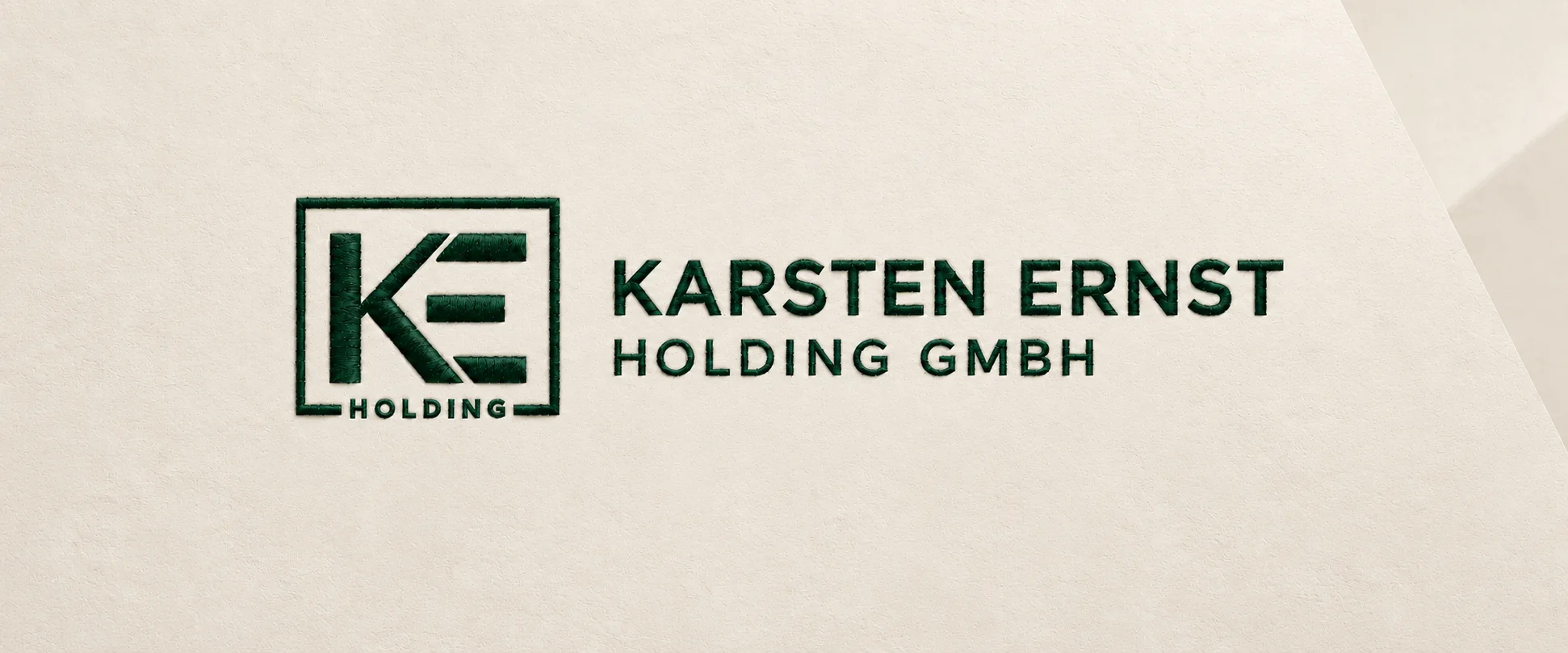 Karsten Ernst Holding GmbH – dunkelgrünes KE-Monogramm und Firmenname als Stickerei auf hellem mineralischem Hintergrund
